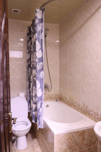 a bathroom with a toilet and a tub and a sink at Al Bukhari Boutique Hotel in Bukhara