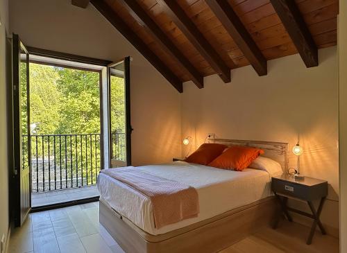 a bedroom with a bed and a large window at Hostal Iratibizkar in Ochagavía