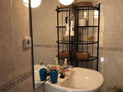 un baño con lavabo y espejo en Canto Simples Rose, en Nazaré