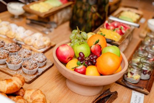 einen Tisch mit einer Schale Obst und Gebäck in der Unterkunft Pezula Nature Retreat in Knysna