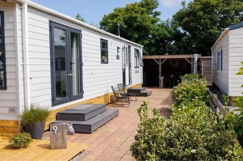 eine Terrasse mit zwei Stühlen und ein Haus in der Unterkunft J 009 in Petten
