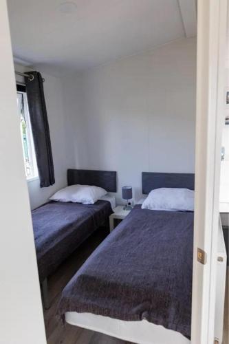ein Schlafzimmer mit zwei Betten und einem Tisch mit Lampe in der Unterkunft J 009 in Petten
