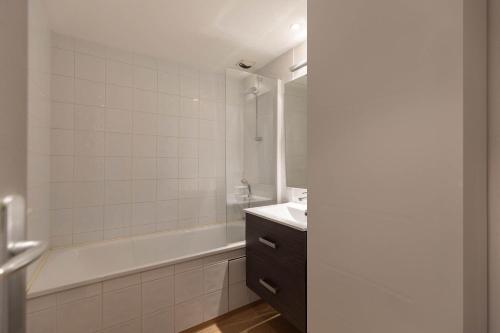 Un baño blanco con bañera y lavabo. en SAINT LARY Appartement Royal Milan 8 personnes, en Saint-Lary-Soulan