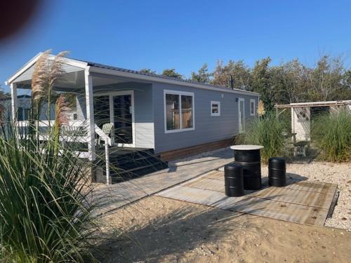 ein winziges Haus auf einer Holzterrasse im Sand in der Unterkunft J 013 in Petten