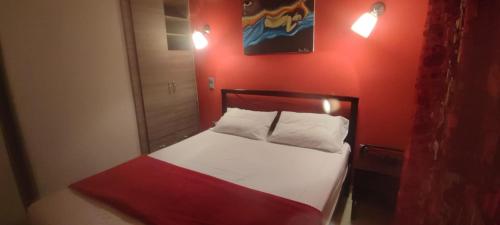 a bedroom with a bed with a red wall at Art house M & F in Órion