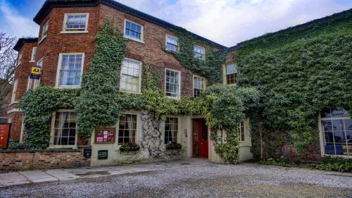 an ivy covered building with a red door at York Pavilion Hotel, BW Signature Collection in York