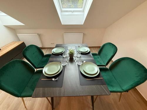 a dining room with a table and green chairs at Family Apartments Zemlinsi 2 in Payerbach