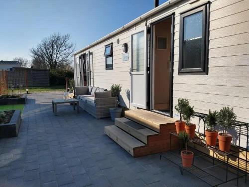 eine Terrasse im Hinterhof mit Sofa und ein Haus in der Unterkunft J 019 in Petten