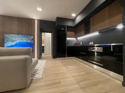 a living room with a couch and a kitchen at Azulis Terme Suite 1 - luxury renovated accommodation in Olbia Center with garden in Olbia