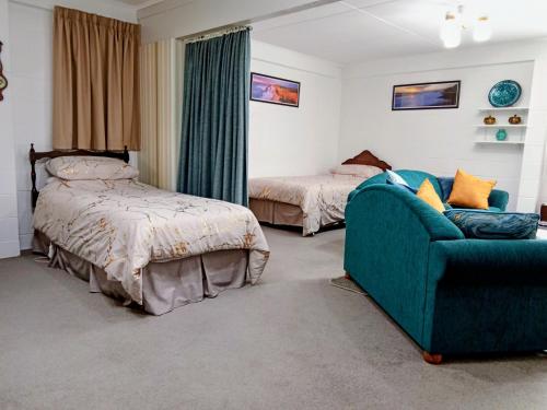 a bedroom with a couch and a bed and a chair at Park View 'Home Away From Home' in Feilding