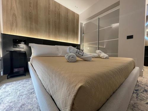 a bedroom with a large bed with two towels on it at Azulis Terme Suite 1 - luxury renovated accommodation in Olbia Center with garden in Olbia