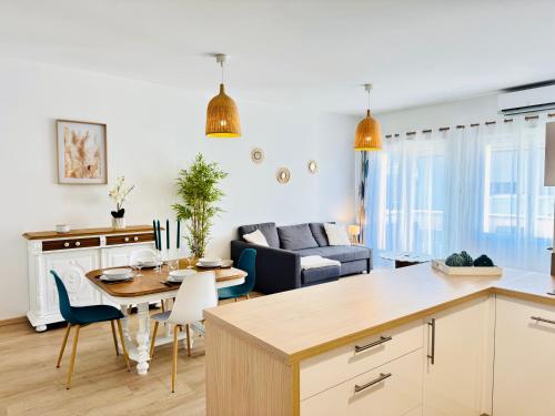 a kitchen and living room with a table and chairs at Le Thieblemont - Elegance and Private Outdoor Space in La Chapelle-Saint-Luc