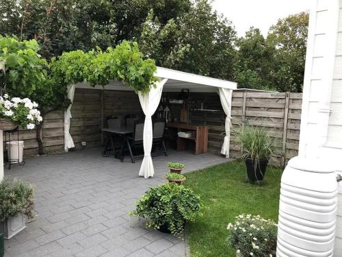 eine Terrasse mit einem weißen Sonnensegel und einem Tisch in der Unterkunft J 059 in Petten