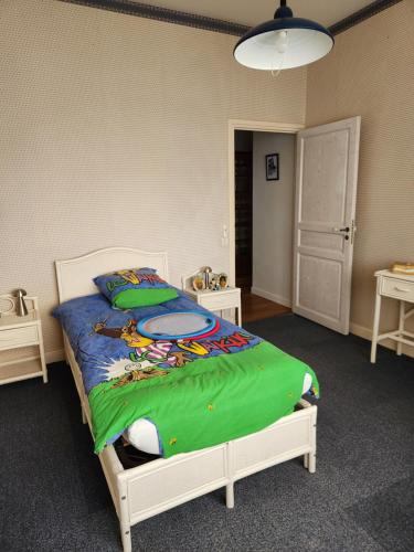 une chambre avec un lit avec une couverture verte dans l'établissement Caz'Amor, à Saint-Sylvestre-sur-Lot