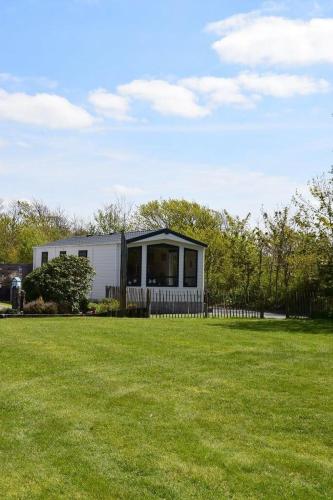 ein kleines Haus in einem Feld mit grünem Gras in der Unterkunft J 071 in Petten