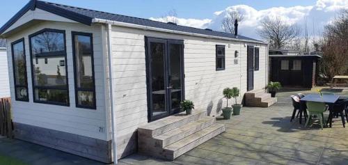 ein kleines Haus mit Terrasse und Tisch in der Unterkunft J 071 in Petten