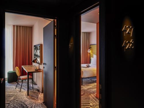 une pièce avec une chambre avec un lit et un miroir dans l'établissement Mama Shelter Dijon, à Dijon