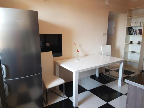 cocina con mesa blanca y nevera en Centrum Noclegowe II, en Bydgoszcz