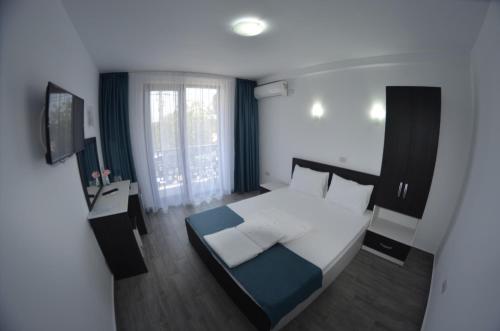 a bedroom with a bed and a television in it at Vila Rares in Costinesti