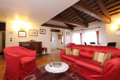 ein Wohnzimmer mit roten Stühlen und einem Tisch in der Unterkunft Zoia Terrace view on St Marks Basilica 150mt in Venedig