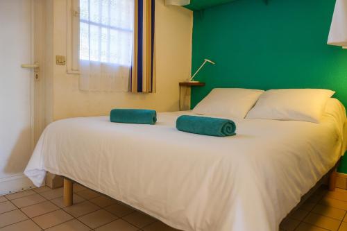 a white bed with two green towels on it at Appartement en rdc - résidence la Goëlette Port Bourgenay - 4 personnes in Saint-Jean-dʼOrbetiers