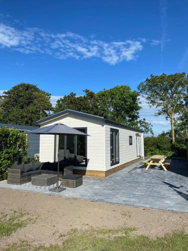 ein kleines weißes Haus mit einem Picknicktisch und einem Picknicktisch in der Unterkunft J121 in Petten