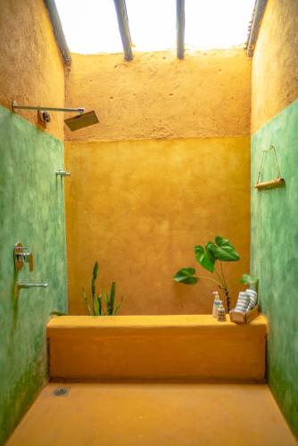 a bathroom with a shower and a tub with a plant at Sakhua stays in Tāla
