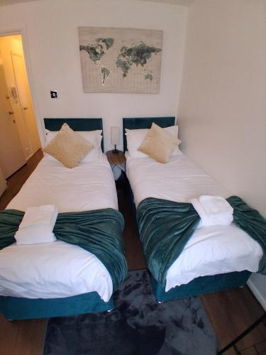 a room with two twin beds and a map on the wall at King's Cross in less than 30mins Home from Home in Enfield