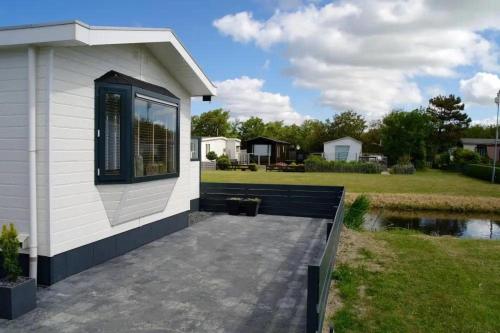 ein kleines weißes Haus mit Terrasse und Garten in der Unterkunft J 134 in Petten
