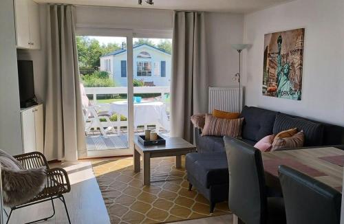 ein Wohnzimmer mit einem blauen Sofa und einem Tisch in der Unterkunft J 174 in Petten