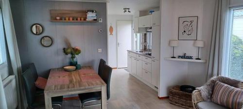 ein Wohnzimmer mit einem Tisch und einer Küche in der Unterkunft J 174 in Petten