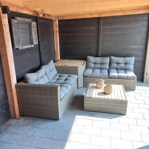 zwei Korbsofas und ein Tisch auf einer Terrasse in der Unterkunft J 217 in Petten