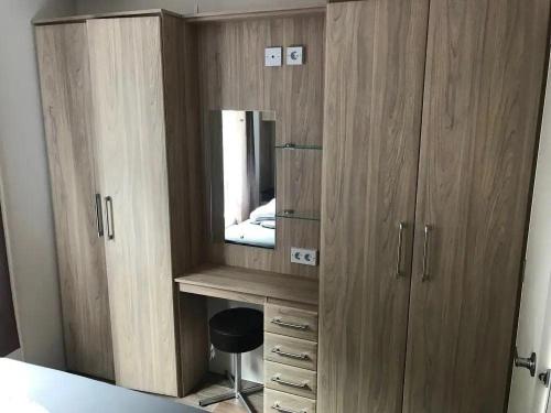 a wooden cabinet with a mirror and a television at Chalet 217 in Petten