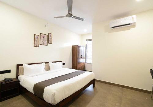 a bedroom with a bed and a ceiling fan at Townhouse Oak NFC Crossway Hyderabad in Maula Ali