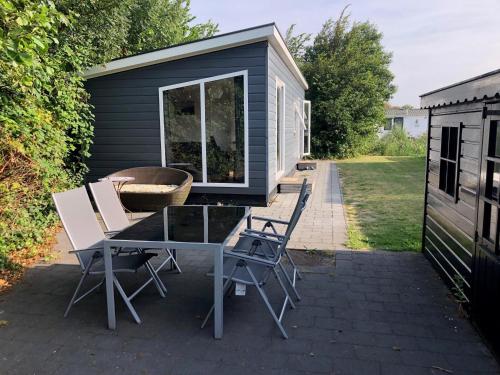 ein Haus mit einem Tisch und Stühlen auf einer Terrasse in der Unterkunft J 106 in Petten