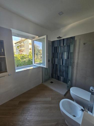 a bathroom with a sink and a toilet and a window at Acquamarina in Sant'Agnello