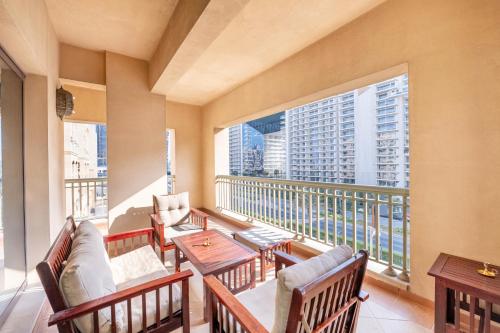 a balcony with tables and chairs and a large window at Ultra Luxury Palm - Free 5-star Beach Resorts Access in Dubai