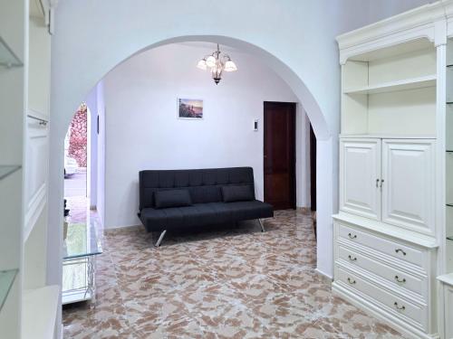 Una sala de estar con un sofá negro en un arco. en Emelina, en La Guancha