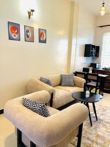 a living room with two couches and a table at Luna Apartment in Dodoma