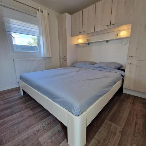 ein Schlafzimmer mit einem großen Bett mit blauen Laken in der Unterkunft J 231 in Petten