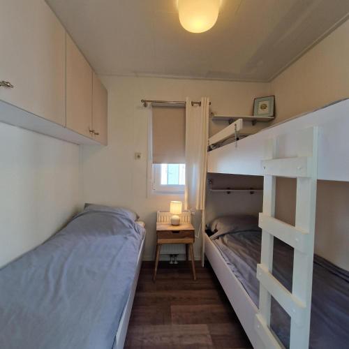 una camera con due letti a castello e un tavolo di Chalet 231 a Petten