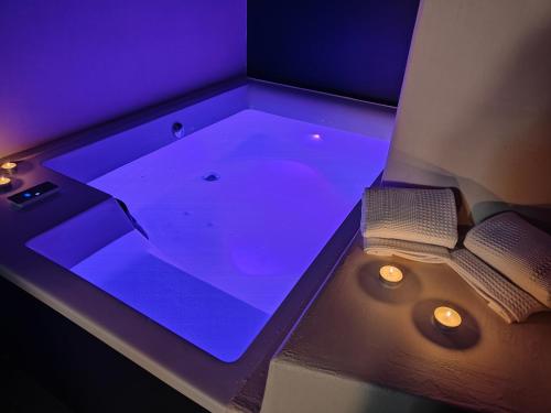 a bath tub with purple lighting in a room at Le Grenier d'Antan - Relax Suite Aosta in Aosta