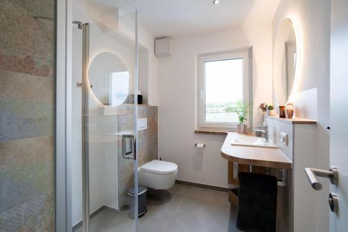 a bathroom with a shower and a toilet and a sink at Campingland Ostsee in Schashagen