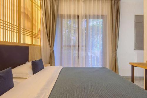 a bedroom with a large bed and a window at Heinemann Hotel Sunny King Room without Bathtub A308 with a jacuzzi and a local in Baoguosi