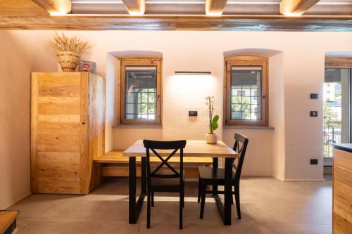 a dining room with a wooden table and chairs at Le Grenier d'Antan - Relax Suite Aosta in Aosta