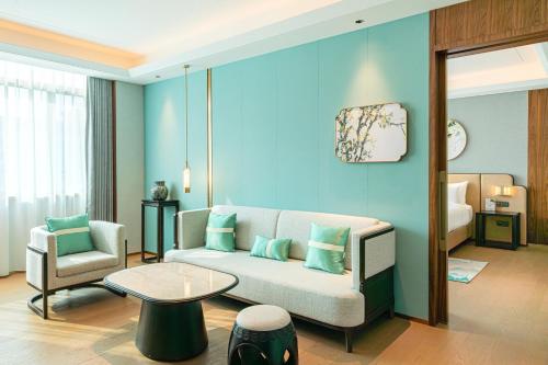 a living room with a couch and a bed at Dong Fang Hotel Guangzhou - Free Canton Fair Shuttle Bus & Overseas Buyer Registration Services in Guangzhou