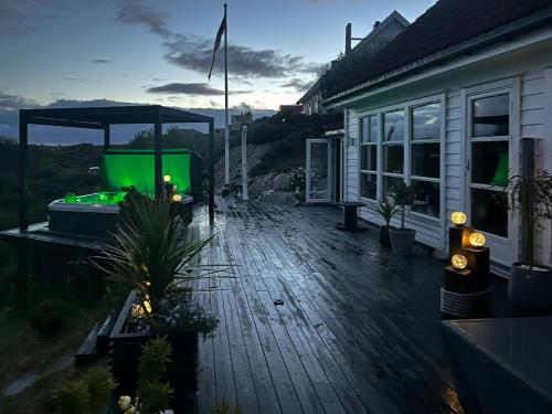a house with a deck with a gazebo at Cabin With Sea Views In Mjømna 