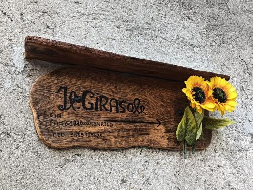 a wooden sign with sunflowers sitting on the ground at Casa vacanze IL GIRASOLE in Santa Brigida
