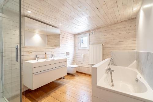 a bathroom with a sink and a tub and a toilet at The Bruges Belfry View in Bruges