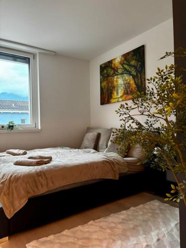 a bedroom with a large bed and a window at Mountain View Apartment in Schattdorf